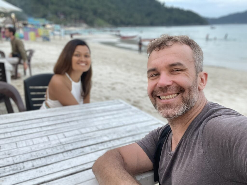 "Roman and Fizah enjoying a beachfront lunch at Perhentian Island with a stunning ocean view."